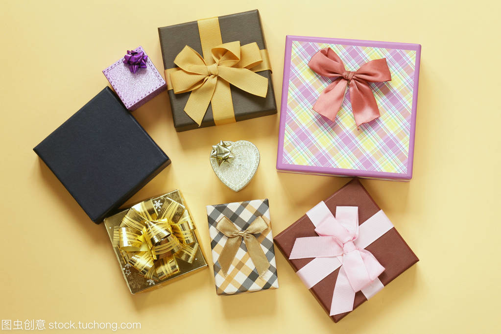 大量的米色背景上蝴蝶結的禮品盒